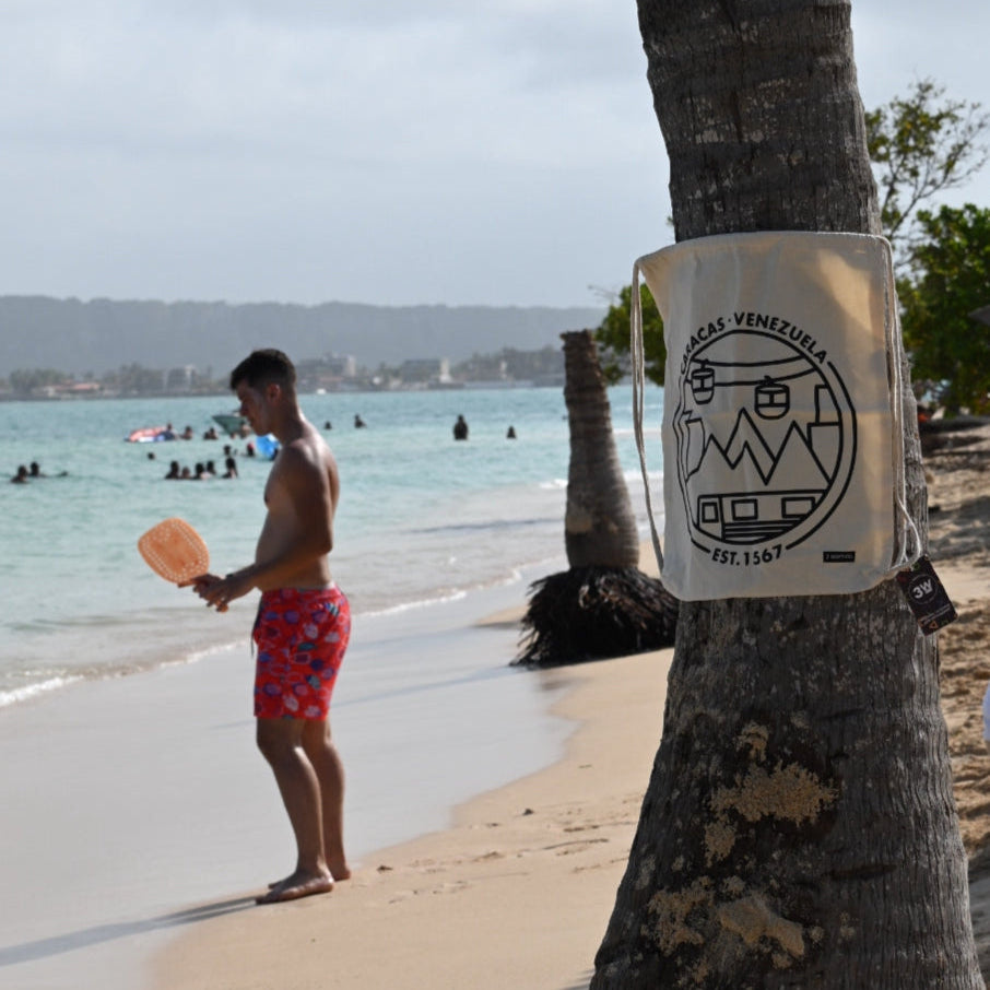 Man on a beach with a palm tree and ocean in the background